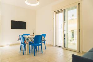 a dining room with a table and blue chairs at ADA Apartment in Porto Cesareo