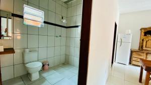 a bathroom with a toilet and a refrigerator at Hostel Agatha in Paraty