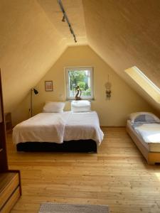 a attic bedroom with a bed and a window at Lieblingsplatz im Grünen - 1 Schlafzimmer in Schweich