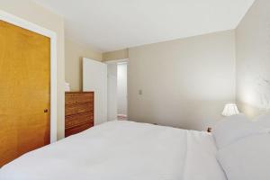 a bedroom with a large white bed and a dresser at Seasons 208 in Warren