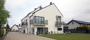 a white building with balconies on a street at Morski Piasek in Grzybowo