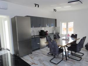 a kitchen with a table and a stainless steel refrigerator at Bellavista in Strožanac