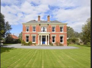 a large brick house with a large grass yard at 1 Bed in Elstronwick oc-e42580 in Burton Pidsea