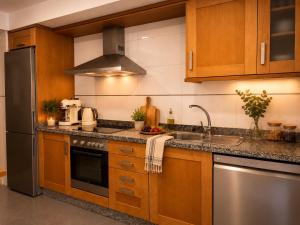 a kitchen with wooden cabinets and stainless steel appliances at Villa María Arrecife Beach in Arrecife
