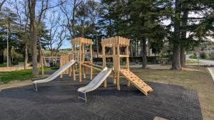 a playground with three slides in a park at Ancarano mobile house & whirlpool in Ankaran