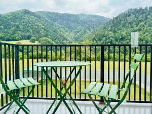 a table and chairs on a balcony with a view of a mountain at Buddy glamping Borjomi in Borjomi +9 photos