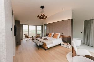 a bedroom with a large bed and a chandelier at De Droomtoren - uniek overnachten in een watertoren nabij Maastricht in Riemst