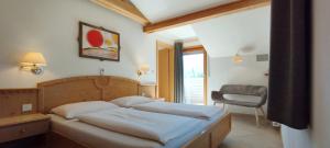 a bedroom with a bed and a chair and a window at Ferienwohnungen Braiter in Rifiano