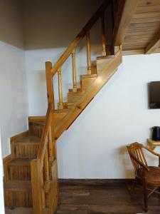 a wooden staircase in a room with a chair at The Kumaon Retreat in Nainital