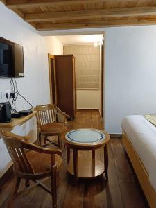 a bedroom with a bed and a table and chairs at The Kumaon Retreat in Nainital