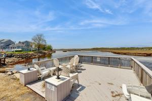 a deck with chairs and a view of the water at Salty Breeze Studio in Wells