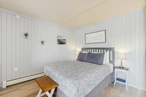 a bedroom with a bed with blue pillows and a table at Salty Breeze Studio in Wells