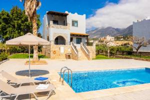 a villa with a swimming pool and a house at Andreas Beach Villa in Sfakia