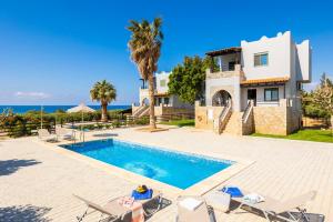 a villa with a swimming pool and a house at Andreas Beach Villa in Sfakia