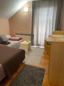 a small room with two beds and a window at Apartman 1 in Krnjača