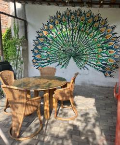 a table and chairs with a painting on the wall at Mtskheta Oasis Garden in Mtskheta
