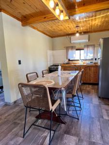 a dining room with a table and chairs in a kitchen at Cabañas Los Robles Premium in Villa Quillinzo