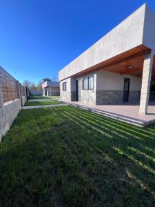a building with a grass yard in front of it at Cabañas Los Robles Premium in Villa Quillinzo