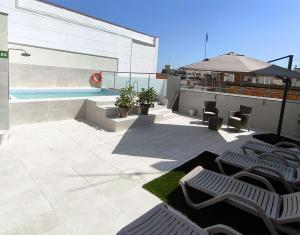 a patio with chairs and an umbrella and a pool at HOTEL BESTPRICE Maragall in Barcelona