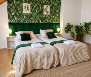 two beds in a room with green and white blankets at KRK stop near airport in Cholerzyn