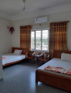 a room with two beds and a table and chairs at Thùy Dung 62 in Ha Long