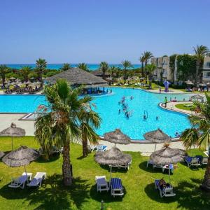 a large swimming pool with chairs and umbrellas at Caribbean World Mahdia in Mahdia