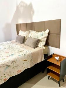 a bed with a large headboard and pillows on it at Casa Lilás no Vale do Capão in Vale do Capao +40 photos