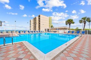 a large swimming pool with a building in the background at Emerald Hideaway by 30A Escapes in Carillon Beach