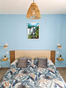 a bedroom with a bed with a blue wall at Lacaze Salazie in Hell-Bourg