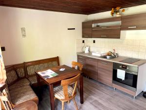 a kitchen with a wooden table and a table and chairs at Chata Lesní Vyhlídka in Splzov