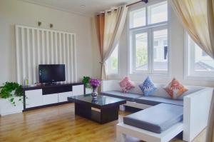 a living room with a couch and a tv at Villa Sealink S15 in Ấp Thiện Phước
