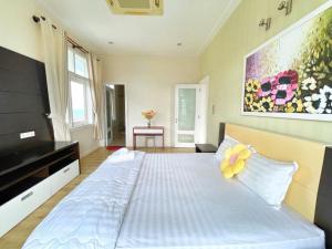 a bedroom with a large bed and a painting on the wall at Villa Sealink S15 in Ấp Thiện Phước