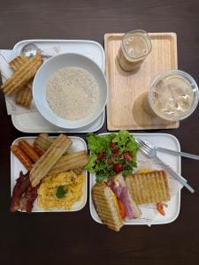 a tray with plates of food and a bowl of soup at After Hours Guesthouse Self Check-in in Bangkok