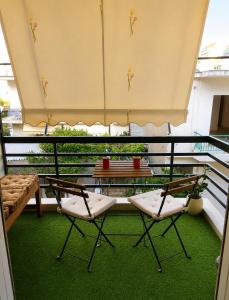 a balcony with two chairs and a table on a balcony at Sunny Living in Loutraki