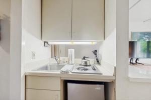 a white kitchen with a sink and a stove at Seasons 303 in Warren