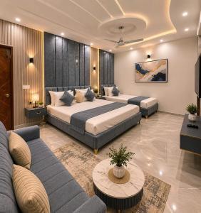 a hotel room with two beds and a couch at Prime Stay Bosan Hotel Multan in Multan