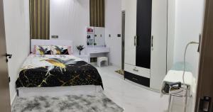 a white bedroom with a bed and a mirror at Save Sweet Home in Fuvahmulah
