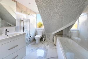 a bathroom with a sink and a toilet and a tub at Charming loft sleeps up to 9 with spa option in Bournemouth