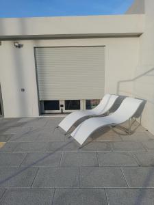 a white bench sitting in front of a building at Alojamento ceu azul in Fernao Ferro