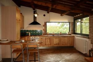 a kitchen with wooden cabinets and a large window at Borgo Santa Cristina in Castel Giorgio