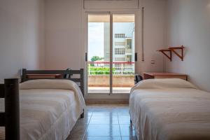 two beds sitting in a room with a window at AT098 Pau Casals in Torredembarra +19 photos