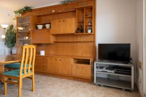 a living room with a tv and a wooden wall at AT098 Pau Casals in Torredembarra