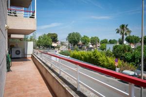 a balcony with a red railing and a street at AT098 Pau Casals in Torredembarra