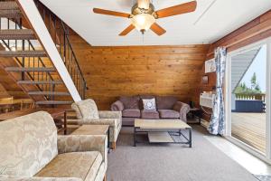 a living room with couches and a ceiling fan at Chalet #25 in Stevensville