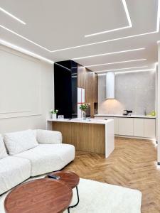 a living room with a white couch and a kitchen at DailyRentKZ in Kostanay