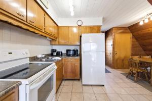 a kitchen with a white refrigerator and a table at Chalet #25 in Stevensville +37 photos