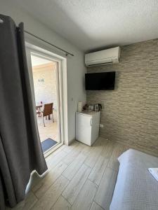 a room with a kitchen and a bedroom with a window at Guest house Kokolo in Hvar