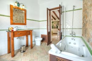 a bathroom with a tub and a toilet and a sink at Petit Caimari - Turismo de interior in Caimari +35 photos