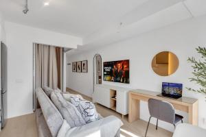 a living room with a couch and a desk at Work-Friendly 1BR Suite Steps to Eaton Centre in Toronto