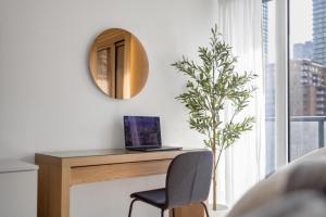 a desk with a laptop and a chair next to a window at Work-Friendly 1BR Suite Steps to Eaton Centre in Toronto +16 photos